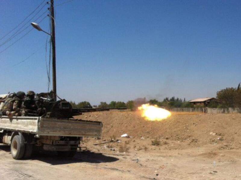 Syrian troops fire a heavy machine gun mounted on a pick-up truck in the Eastern Ghouta area on the northeastern outskirts of Damascus on August 30, 2013. (AFP)