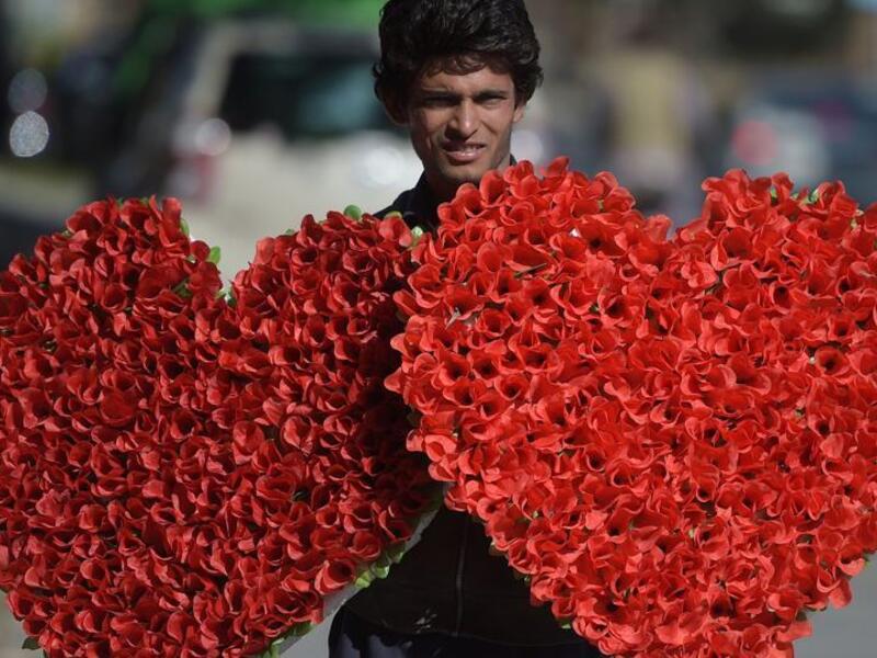 A Pakistani vendor carries heart-shaped bouquets for sale ahead of Valentine's Day along a street in Islamabad on February 13, 2017. (AFP)