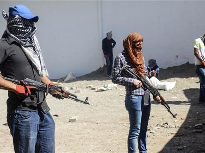 Kurdistan Workers’ Party (PKK) militants stand behind a barricade during clashes with Turkish forces in the Bismil district of Diyarbakir Province, September 28, 2015. (AFP/File)