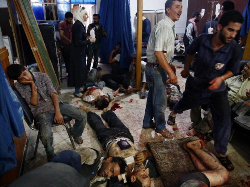 Civilians in Douma receive medical treatment after regime airstrikes August 2015. (AFP/File)
