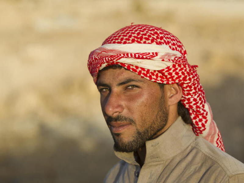 Bedouin camel herder wears a shemagh at sunset in Jordan (Shutterstock/Martin Good)