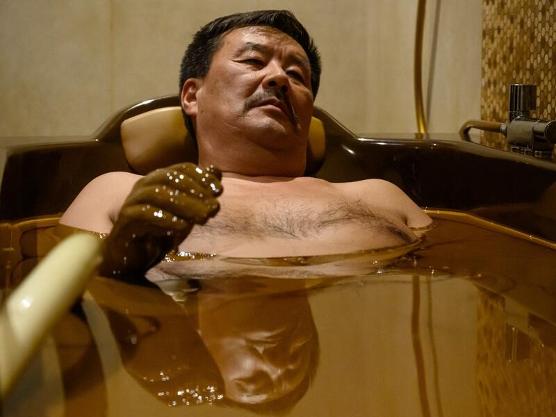 A man bathes in a tub filled with Naftalan crude oil during a treatment session at Qarabag luxury resort in Naftalan, some 300 kilometres (186 miles) from capital Baku, on March 21, 2019. Immersed up to her neck in crude oil, a Russian woman suffering from joint disease smiles in delight, confident that the treatment at a spa in northwestern Azerbaijan will cure her painful condition.  Mladen ANTONOV / AFP