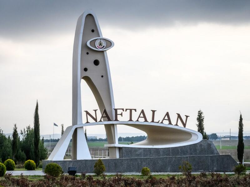 A monument at the entrance of the city of Naftalan is pictured on March 21, 2019, some 300 kilometres (186 miles) from capital Baku. Immersed up to her neck in crude oil, a Russian woman suffering from joint disease smiles in delight, confident that the treatment at a spa in northwestern Azerbaijan will cure her painful condition.  Mladen ANTONOV / AFP