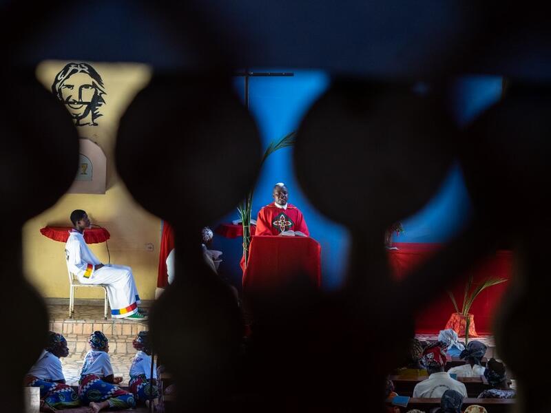 Father Celso Taibo attend a mass during Palm Sunday on April 14, 2019 at Lady of Grace Parish Catholic Church in Barrio Manasse, Buzi District, Sofala Province, Mozambique. Congregants marched the streets of Buzi town skipping rubbles to pass huge fallen trees and buildings with no roofs, windows or doors, one month following the cyclone Idai that killed more than 600 people and displaced 150 000 people in Mozambique.  Zinyange AUNTONY / AFP