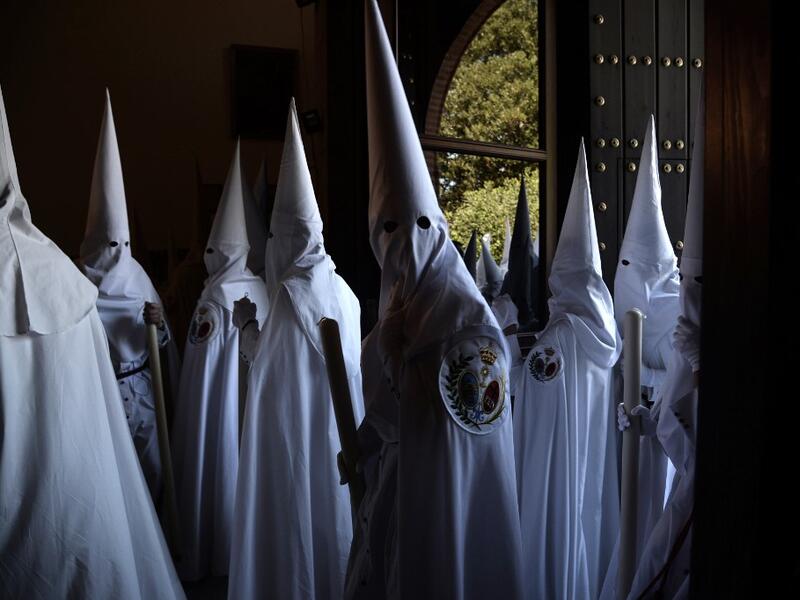 Penitents of the 'La Paz' brotherhood parade during a Palm Sunday procession in Sevilla as part of the Holy Week on April 14, 2019.  CRISTINA QUICLER / AFP