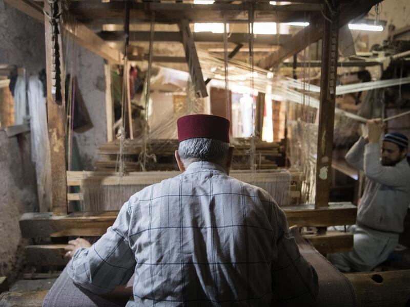 Abdelkader Ouazzani, the last of Morocco's brocade master weavers, displays tapestry at his workshop in the old city of Fez on April 10, 2019. His skilfull hands intricately create shimmering silk fabrics, enhanced with gold or silver thread, for bridal jewellery, designer creations or high-end furnishings. FADEL SENNA / AFP