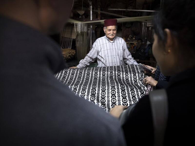Abdelkader Ouazzani, the last of Morocco's brocade master weavers, displays tapestry at his workshop in the old city of Fez on April 10, 2019. His skilfull hands intricately create shimmering silk fabrics, enhanced with gold or silver thread, for bridal jewellery, designer creations or high-end furnishings. FADEL SENNA / AFP