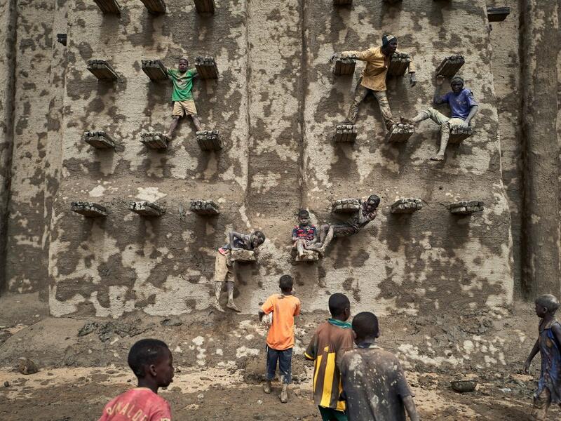 People take part in the annual rendering of the Great Mosque of Djenne in central Mali  MICHELE CATTANI / AFP