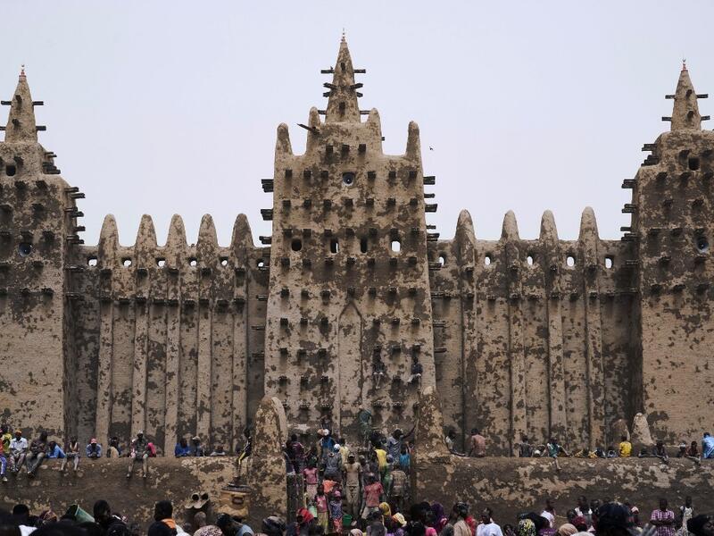 People take part in the annual rendering of the Great Mosque of Djenne in central Mali  MICHELE CATTANI / AFP