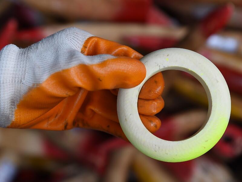 A member of a wildlife personnel team displays a product made from ivory tusks before the confiscated ivory was destroyed at the Kualiti Alam Waste Management centre in Port Dickson on April 30, 2019.  Mohd RASFAN / AFP