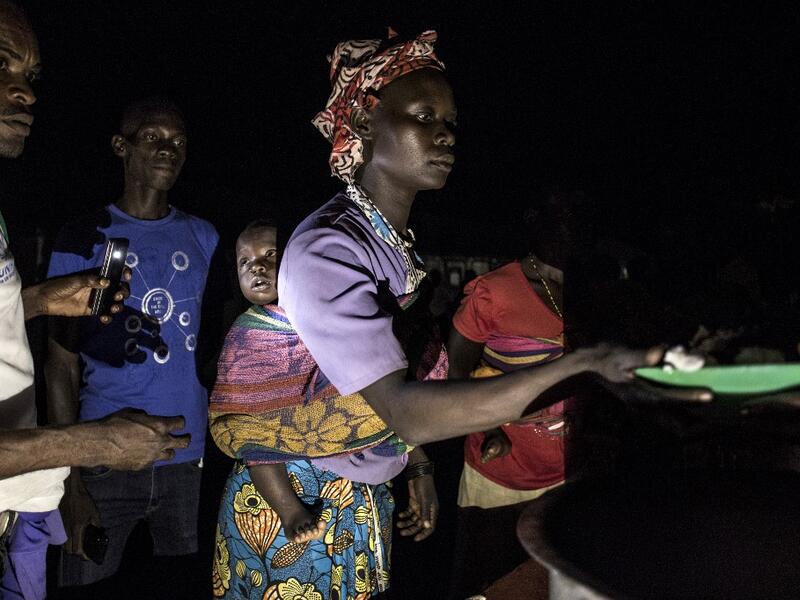 South Sudanese Refugees receive food after being transported from the border of South Sudan and the Democratic Republic of the Congo (DRC) to a refugee settlement site  JOHN WESSELS / AFP