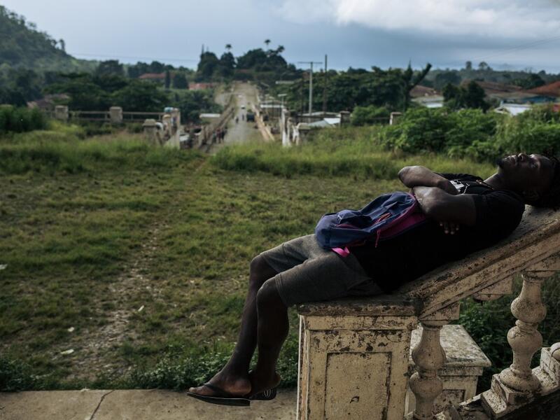 Willy, inhabitant of the roca Agostinho Neto, an abandoned cocoa plantation of Sao Tome and Principe, sleeps in front of the abandoned hospital of the roca, on May 12, 2019.  Alexis HUGUET / AFP