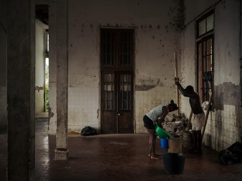 Inhabitants of the roca Agostinho Neto, an abandoned cocoa plantation of Sao Tome and Principe, prepare corn in the former hospital of the roca, on May 29, 2019.  Alexis HUGUET / AFP