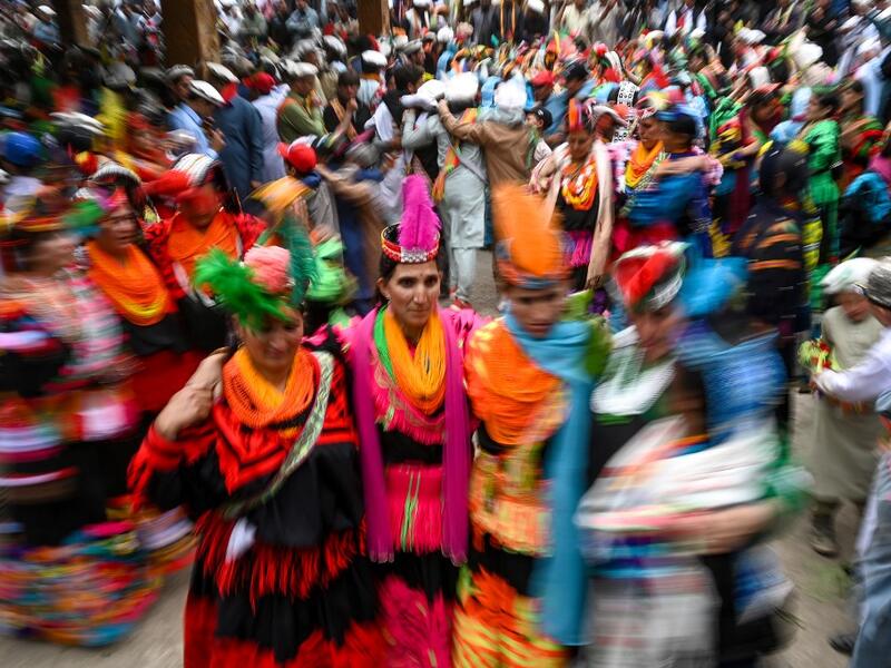 Kalash women wearing traditional dresses dance as they celebrate 'Joshi', a festival to welcome the arrival of spring, at Bumburate village in the mountainous valleys in northern Pakistan.  AAMIR QURESHI / AFP