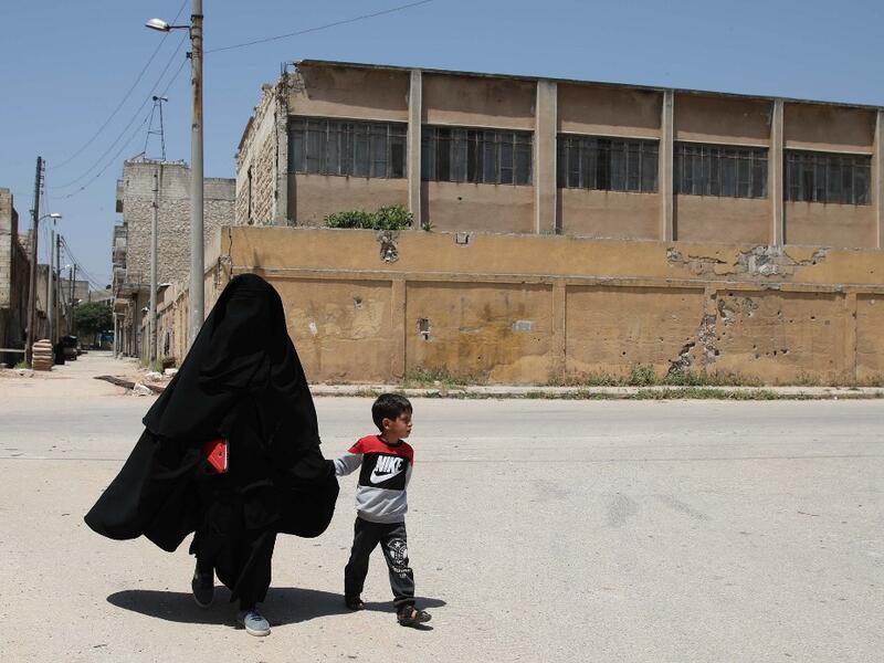 Hasna Dbeis, a 30-year-old former detainee in a Syrian-regime jail, holds her son Mohammad's hand, as they walk in the town of Maarat Nasrin, in the rebel-held part of the Syrian Idlib province  Aaref WATAD / AFP