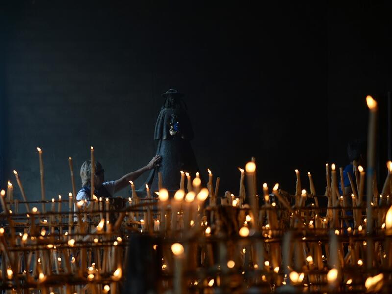 A pilgrim touches the effigy of the Rocio Virgin at the church of the village of El Rocio  CRISTINA QUICLER / AFP
