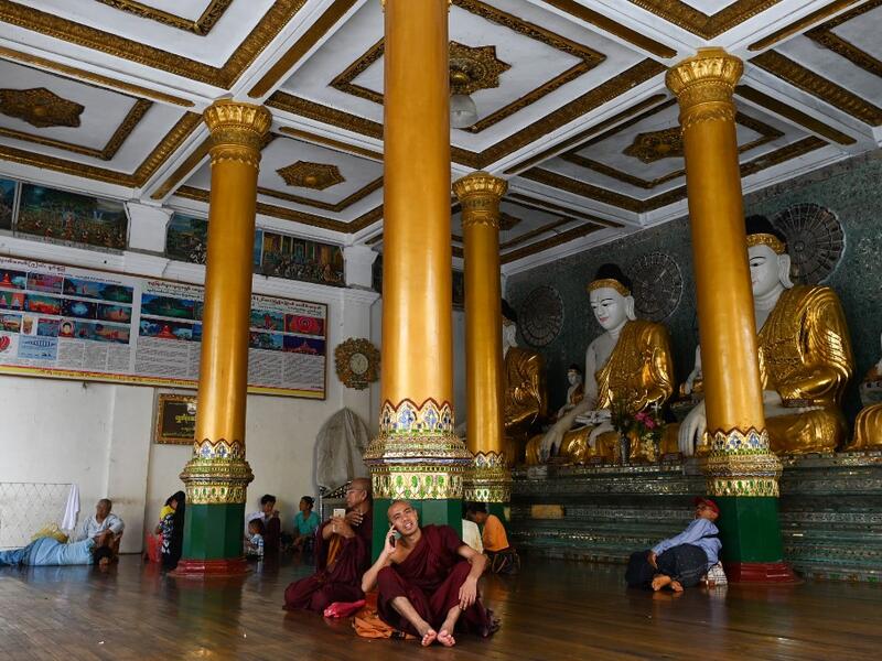 Buddhist monks and devotees rest in a temple at the Shwedagon pagoda in Yangon on June 14, 2019.  Ye Aung THU / AFP