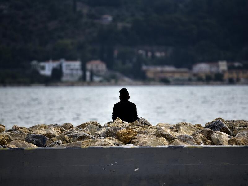 A migrant watches the sea at Samos' island capital city of Vathy.  LOUISA GOULIAMAKI / AFP