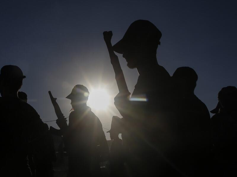 Palestinian youth, carrying wooden rifles, take part in a military-style graduation ceremony organised by the Islamic Jihad movement in Gaza City on July 4, 2019.  MOHAMMED ABED / AFP