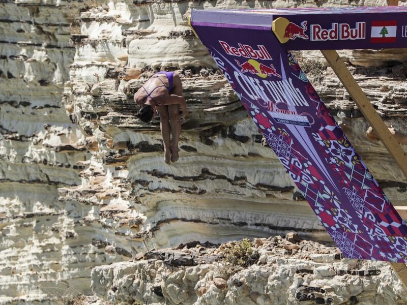 A cliff diver jumps from a platform on the landmark Raouche sea rock off the coast of the Lebanese capital Beirut on July 14, 2019, during the women's 2019 Red Bull Cliff Diving World Series.  ANWAR AMRO / AA / AFP