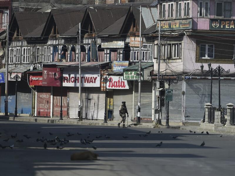 An Indian paramilitary trooper patrols along an empty street during a strict curfew in Lal Chowk area of Srinagar on the 8th day of Muharram (AFP)