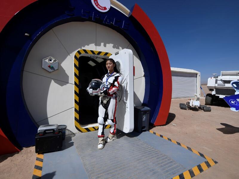 A guide wearing a space suit stands at an entrance at "Mars Base 1", a C-Space Project, in the Gobi desert, some 40 kilometres from Jinchang in China's northwest Gansu province on April 17, 2019. WANG ZHAO / AFP