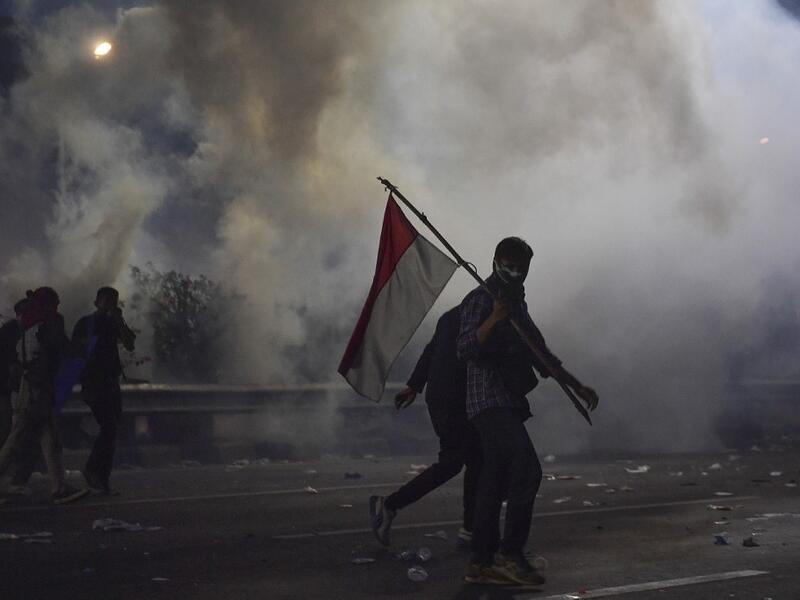 Students try to take cover as police shoot tear gas during a protest outside the parliament building in Jakarta on September 30, 2019. (AFP/ File Photo)
