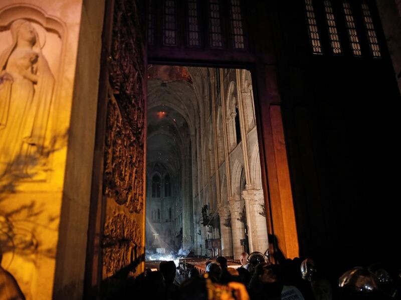 This general view from the entrance shows smoke rising in front of the altar cross at Notre-Dame Cathedral in Paris on April 15, 2019, after a fire engulfed the building. PHILIPPE WOJAZER / POOL / AFP