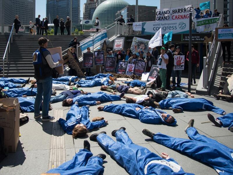 Activists of 'Extinction Rebellion' (XR) and NGO 'Planete Amazone' lie on the ground to stage an action called "die-in" to highlight the risk of the human race becoming extinct as a result of climate change, during a protest against large hydroelectric dams in front of the Grande Arche de La Defense, in Puteaux, northwest of Paris, on May 14, 2019. AFP