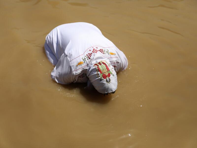 A Coptic Egyptian pilgrim submerges herself in the waters of the Jordan River after she was baptized on April 23, 2019 at the Qasr al-Yahud baptismal site near the West Bank city of Jericho as part of their Easter pilgrimage to the holy Land. According to the gospels Jesus Christ was baptized in the waters of the Jordan River by John the Baptist. GALI TIBBON / AFP