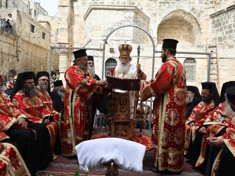 Greek Orthodox Patriarch of Jerusalem, Theophilos III (C), leads the traditional Washing of the Feet ceremony in front of the church of the Holy Sepulchre in Jerusalem's Old City, on April 25, 2019, as part of the Orthodox Holy Week celebrations.  GALI TIBBON / AFP