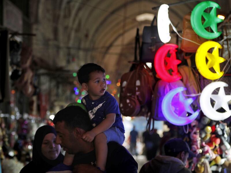 Palestinians walk past shops decorated ahead of the Muslim holy fasting month of Ramadan, in Jerusalem's old city on May 2, 2019.  AHMAD GHARABLI / AFP