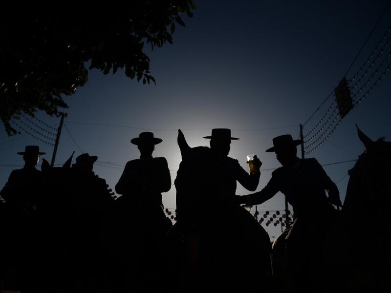 Horsemen drink typical "rebujito" (Sherry with lemon soda) during the "Feria de Abril" (April Fair) festival in Seville on May 6, 2019. CRISTINA QUICLER / AFP