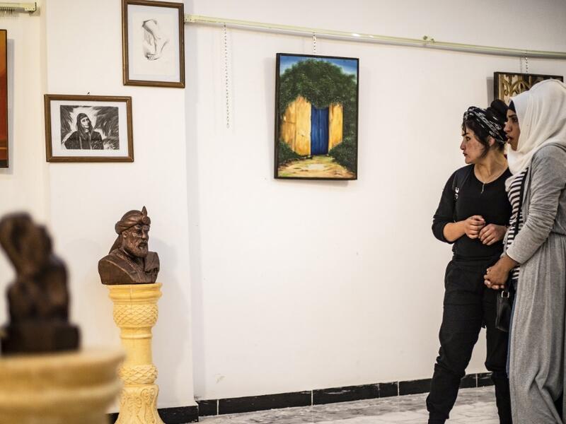 Residents of the eastern Syrian city of Raqa view artworks during an exhibition at the first cultural centre to open since ISIS rule ended there, on May 1, 2019. DELIL SOULEIMAN / AFP