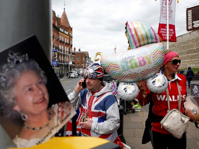 Royal super fans John Loughery (L) and Anne Daley stand near Windsor Castle, west of London on May 6, 2019, with baby-themed items as they wait for news of the imminent birth of the child of Britain's Prince Harry and Meghan, Duke and Duchess of Sussex.  ADRIAN DENNIS / AFP