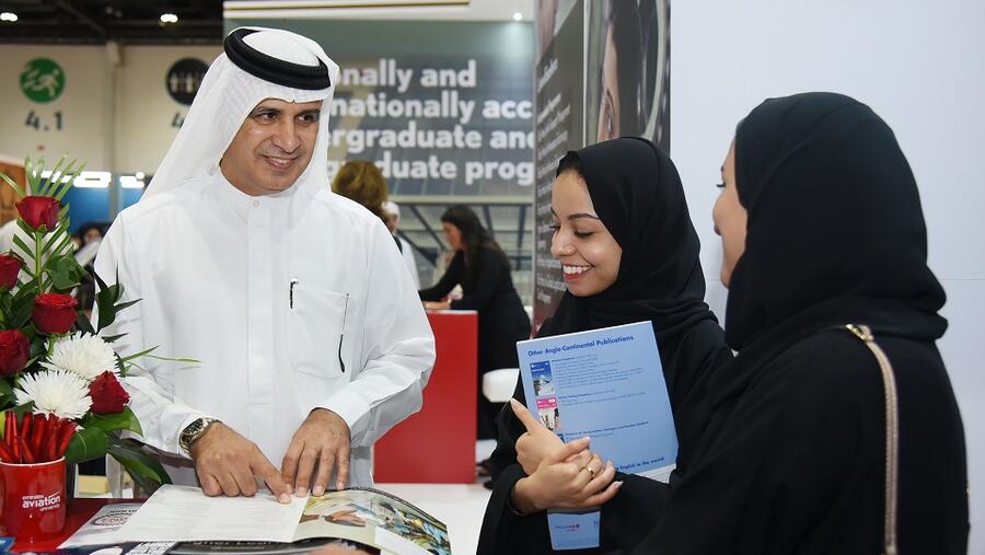 الدكتور أحمد آل علي، مدير جامعة الإمارات للطيران مع طالبتين خلال معرض نجاح للتعليم