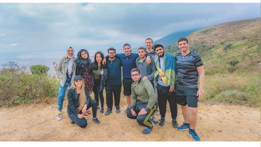 الطلاب الذين شاركوا في الرحلة التعليمية إلى تنزانيا في صورة جماعية مع المستشار الأكاديمي