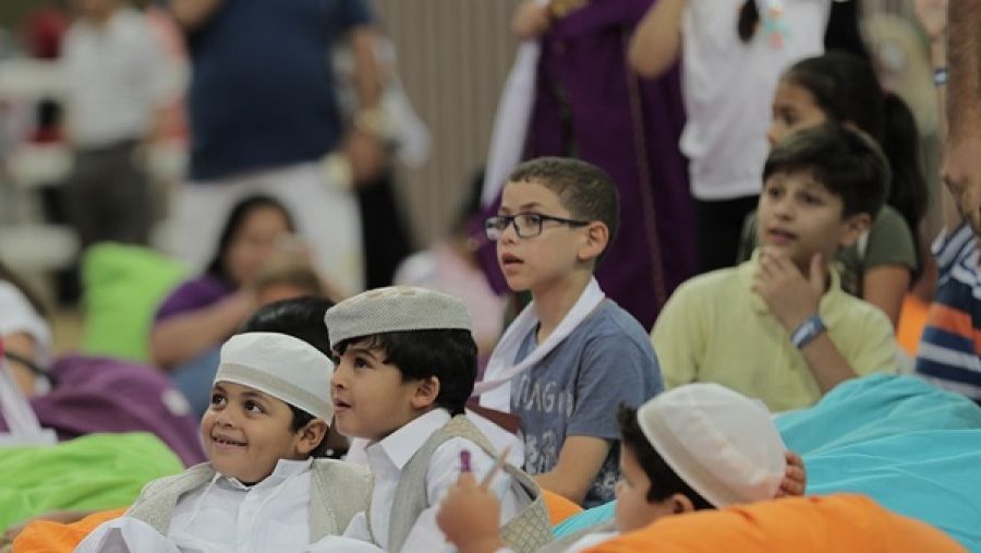 أطفال يستمعون إلى القصص خلال احتفالات مؤسسة قطر بليلة القرنقعوه في الشقب