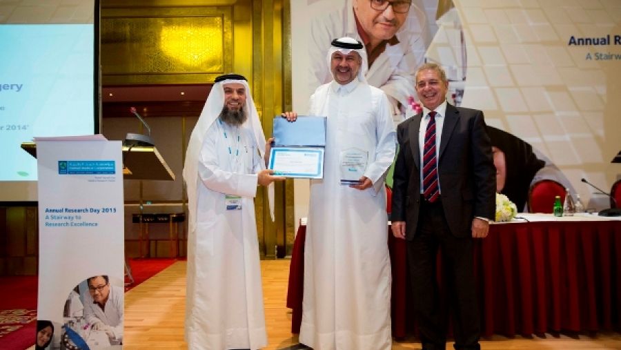 الدكتور عبدالله الأنصاري (وسط) نائب رئيس الشؤون الطبية والأكاديمية والبحوث لخدمات الجراحة، يتسلم جائزة أفضل إدارة عن قسم الجراحة قدمها البروفيسور الجناحي (يسار) والبروفيسور هيلهاوس (يمين).  
