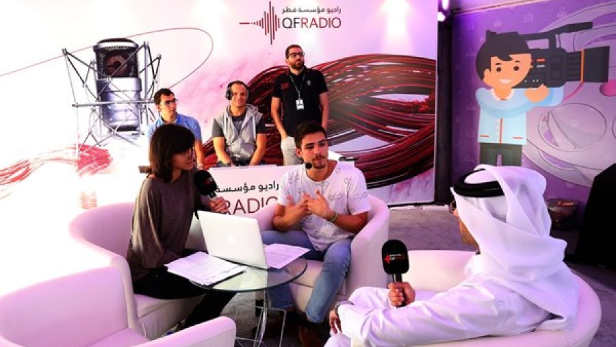 مقدّم برامج في راديو مؤسسة قطر يعقد مقابلة حيّة مع شابين مشاركين من زائري المهرجان