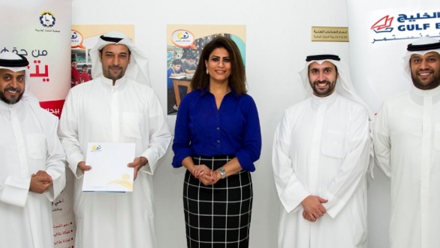 فريق بنك الخليج يتوسط فريق لجنة طالب العلم خلال تقديم منح الأيتام الدراسية بمناسبة اليوم العالمي لمحو الأمية.