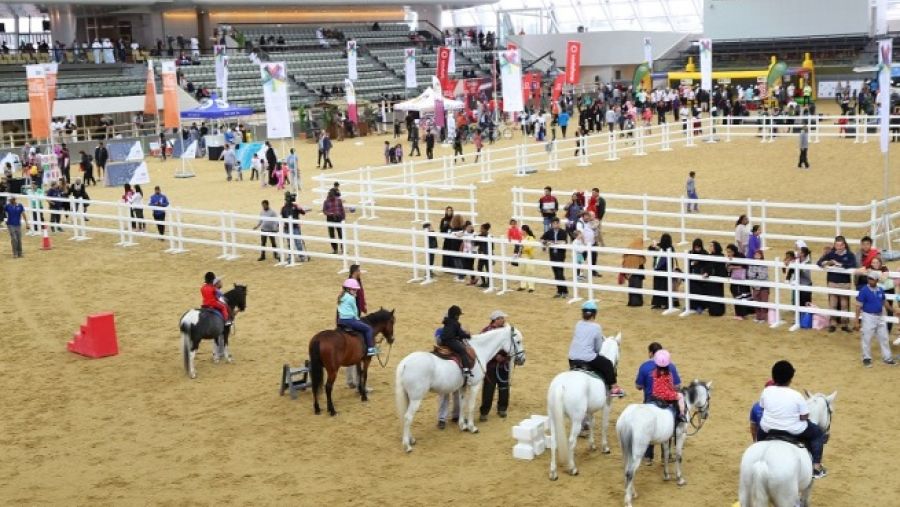 أطفال يستمتعون بركوب الأمهر ضمن الفعاليات التي نظمتها مؤسسة قطر للاحتفال باليوم الرياضي للدولة.