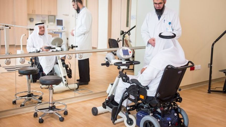 باسم عويس متخصص العلاج الطبيعي أثناء إجراء جلسة علاج طبيعي للمريض جاسم محمد علي عبد الله في صالة التمارين الرياضية العلاجية بمركز قطر لإعادة التأهيل 