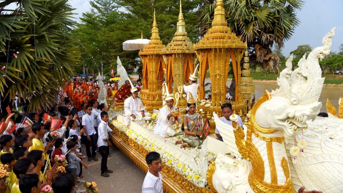 Cambodian people throw to a dragon float during the Visak Bochea Buddhist celebration at a pagoda in Phnom Penh on May 18, 2019. TANG CHHIN Sothy / AFP