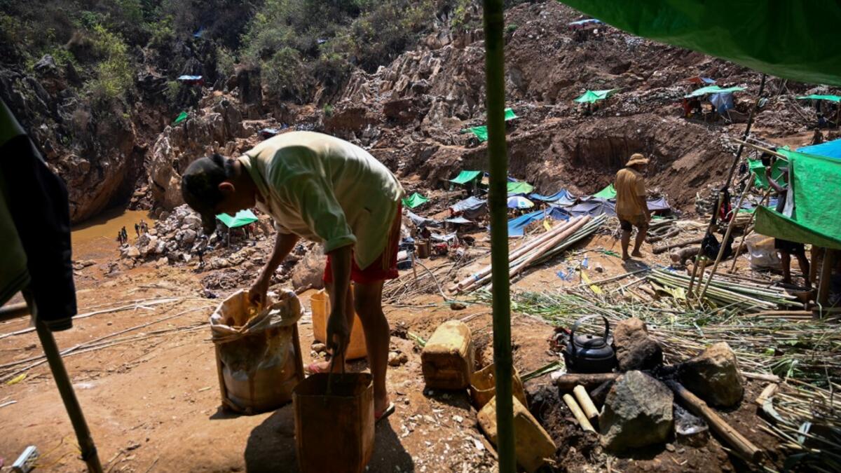 This photo taken on May 16, 2019 shows miners collecting earth containing rubies and other gemstones in a ruby mine in Mogok, north of Mandalay. Burrowing deep underground, thousands of informal miners risk their lives to find gleaming red gems as a law change spurs opportunity in Myanmar's "land of rubies". Ye Aung THU / AFP