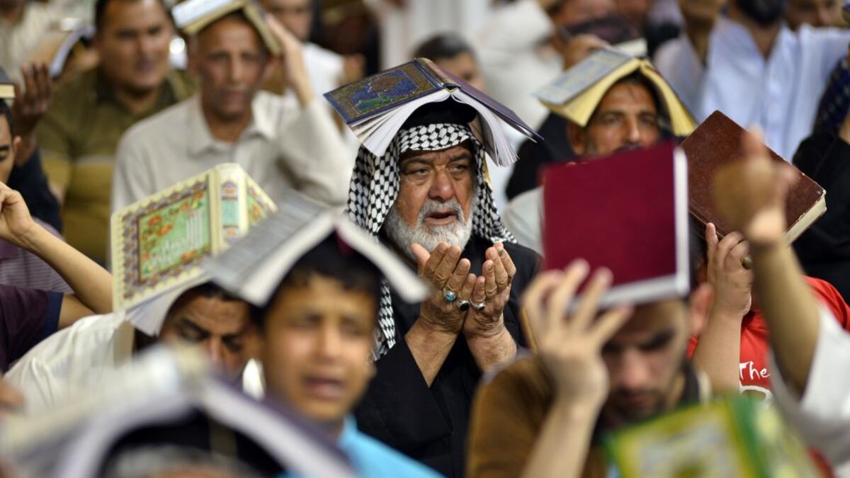 Shiite Muslims gather for the ritual prayer of Lailat al-Qadr, which marks the night in fasting month of Ramadan during which the Koran was first revealed to Prophet Mohammed in the seventh century, at the Imam Ali shrine in the central Iraqi holy city of Najaf on May 29, 2019.  Haidar HAMDANI / AFP