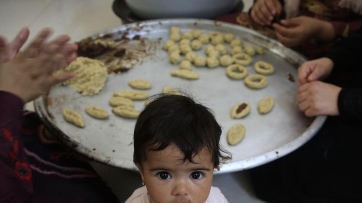 Palestinian women prepare traditional cookies ahead of the Eid al-Fitr festivities, celebrating the end of the holy Muslim fasting month of Ramadan, in Beit Lahia in the northern Gaza Strip on May 29, 2019.  MOHAMMED ABED / AFP