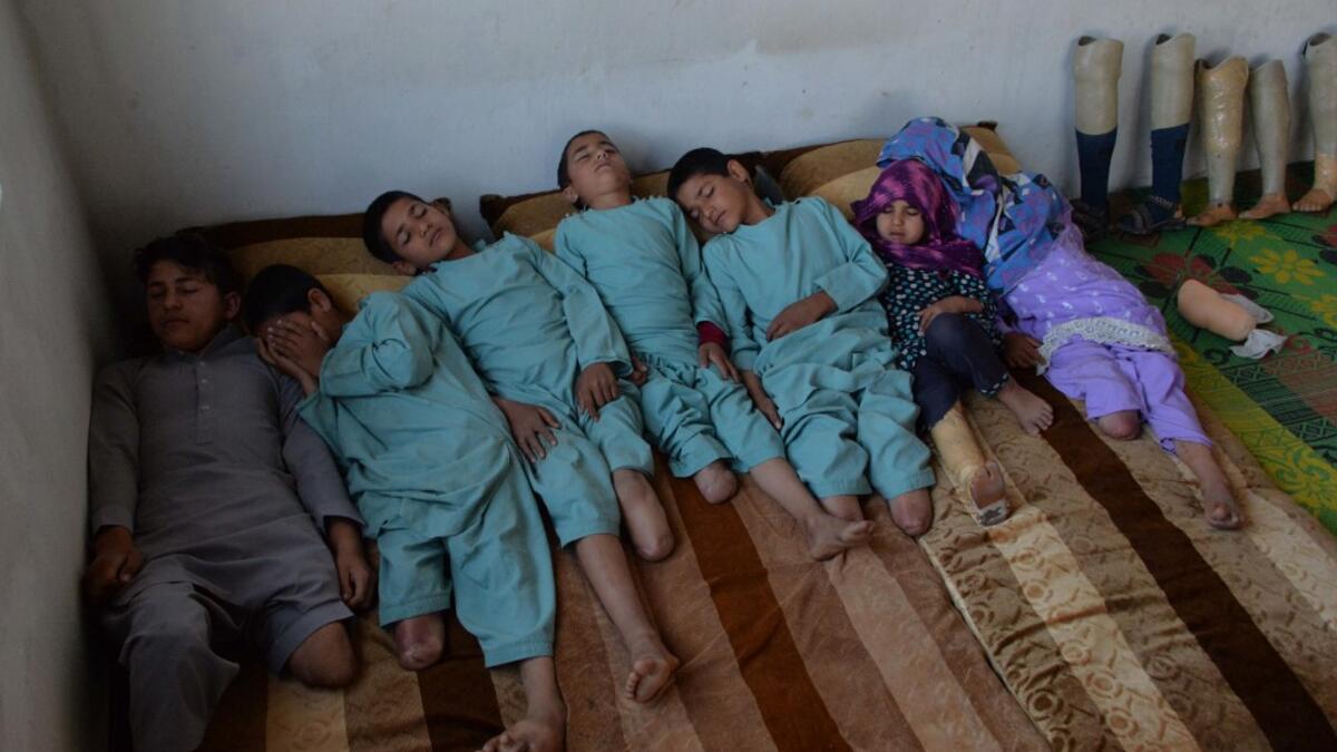 In this photograph taken on May 3, 2019, Hamisha Gul’s sons and grandchildren, who lost their legs following unexploded rocket explosion, rest in their bedroom in Khogyani district of Nangarhar province. NOORULLAH SHIRZADA / AFP