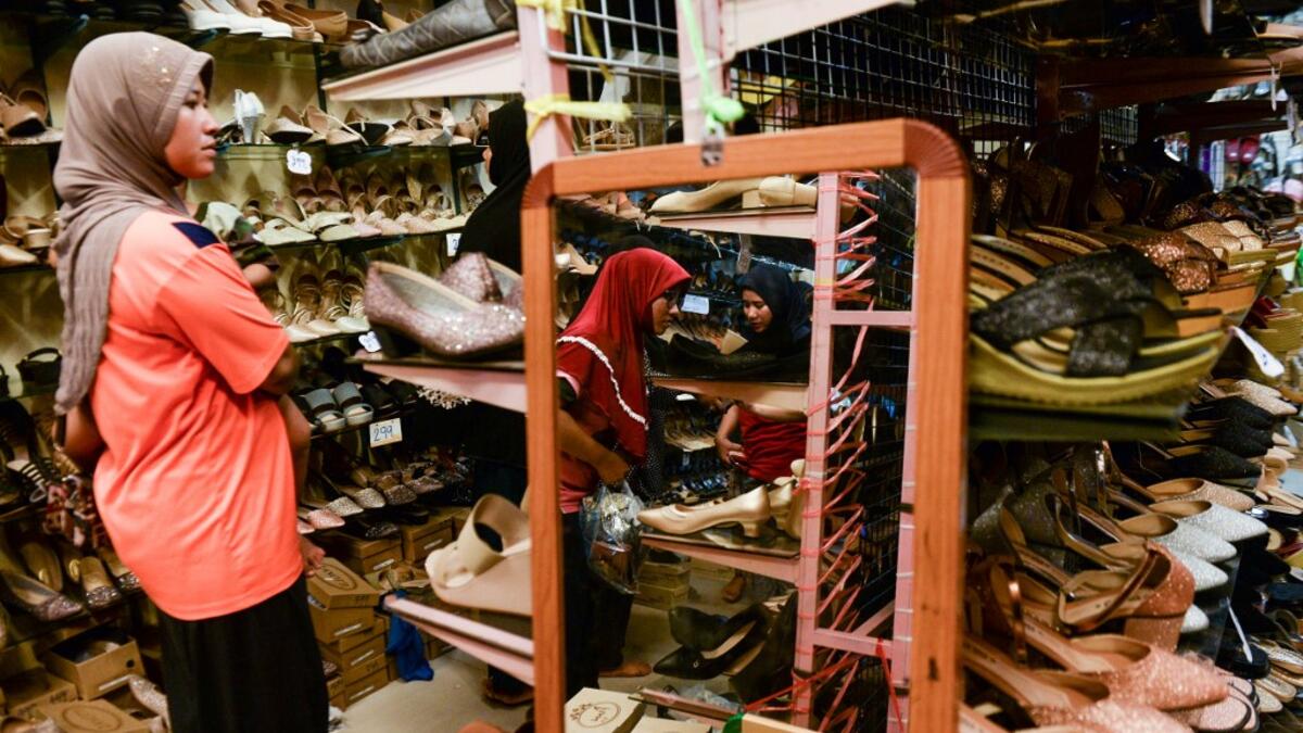 In this picture taken on June 1, 2019 Muslim women browse shoes in a store while shopping for Eid-al-Fitr, which marks the end of the holy month of Ramadan, in Narathiwat.  Madaree TOHLALA / AFP
