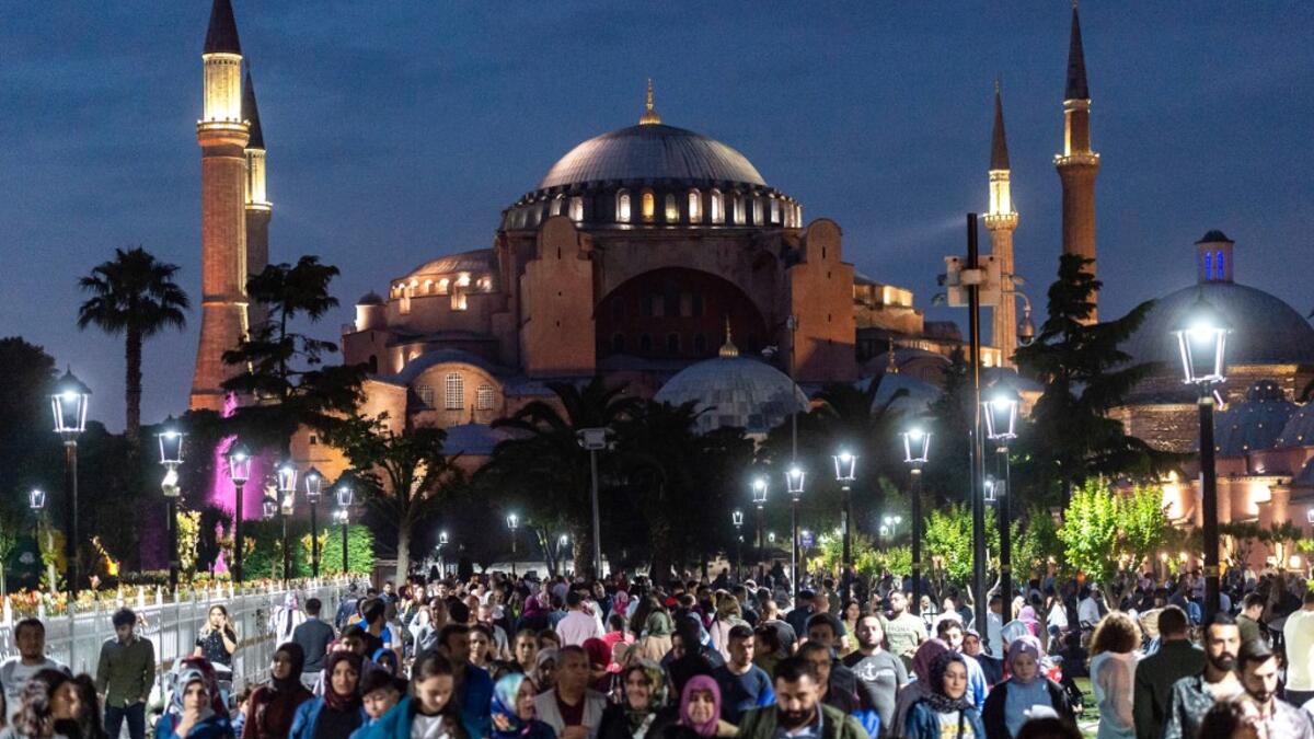 People stroll at the sunset in front of the Blue Mosque square during of the holy month of Ramadan on June 1, 2019 in Istanbul. The world's nearly 1.5 billion Muslims on May 27 began Ramadan, the holy month of dawn-to-dusk fasting and prayers. It is sacred to Muslims because tradition says the Koran was revealed to the Prophet Mohammed during that month. Yasin AKGUL / AFP